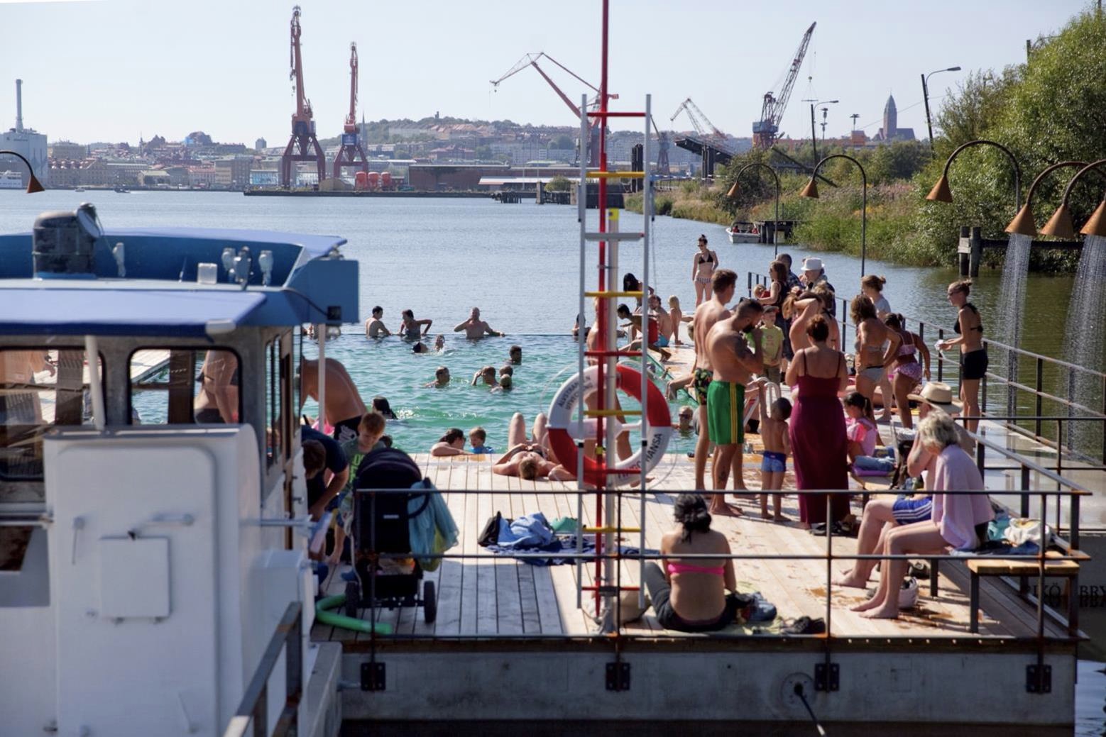 The floating pool at Jubileumsparken in Gothenburg harbour, shipyard cranes across the water