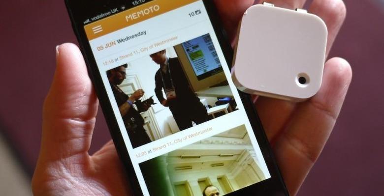The Memoto camera held beside a phone showing the app's photo timeline